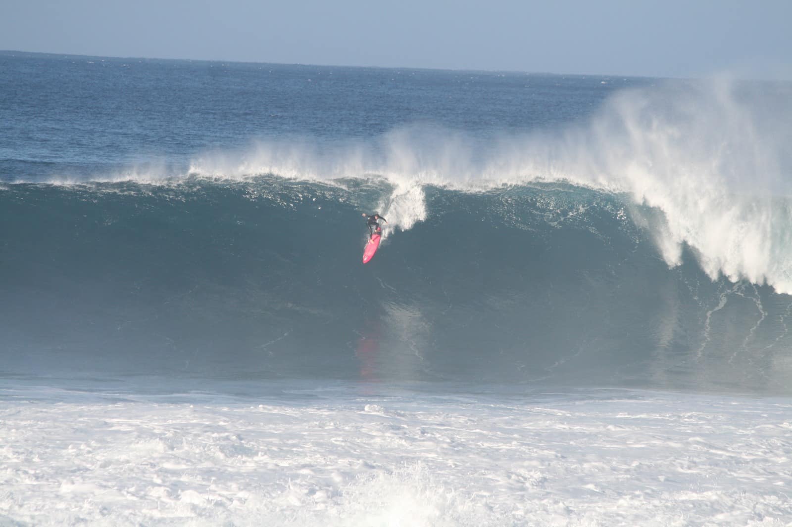 Surfista a descer uma onda grande.